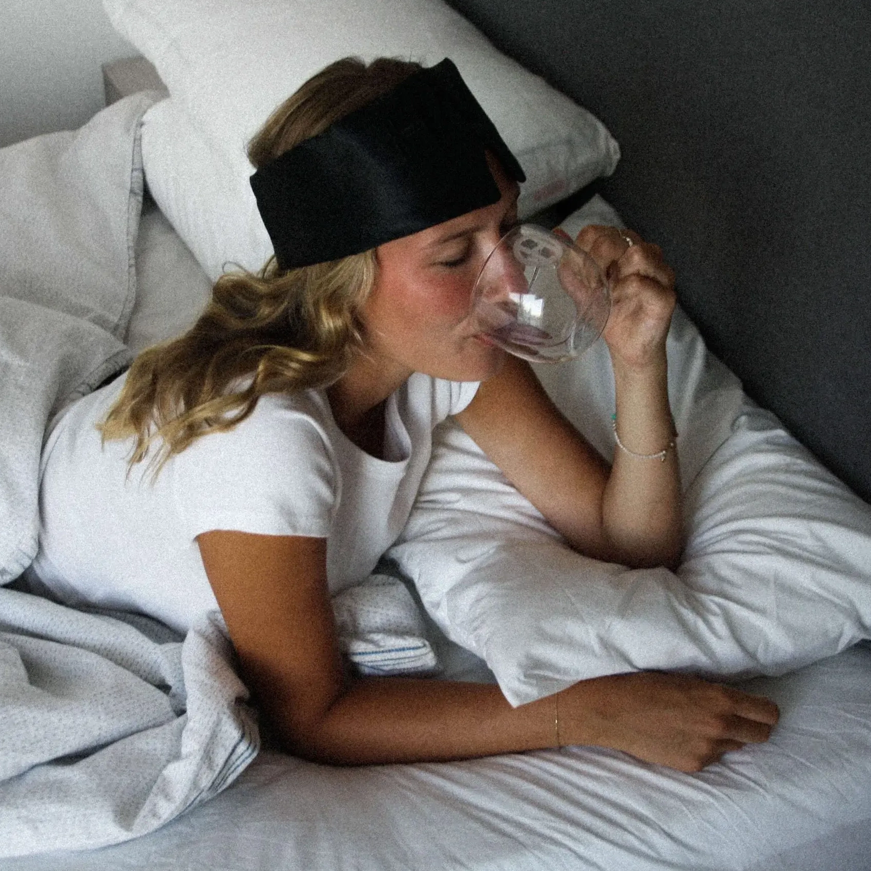 Model drinking Night Blend Sleep Supplement wearing HAKD Deep Sleep Mask