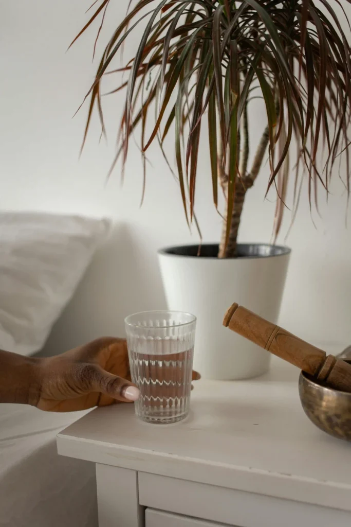 Can’t Sleep After Drinking? Why It Happens & How to Fix It 2 Glass of water on bedside table to improve sleep after drinking alcohol