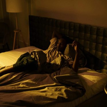 Lying awake in bed at 4:24 AM, struggling with insomnia and poor sleep quality, highlighting the need for a natural sleep aid.