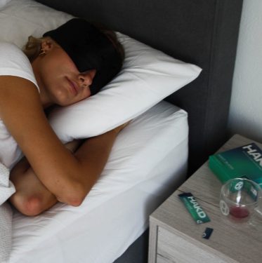 Person sleeping in a dark, quiet bedroom to highlight optimal sleep environment